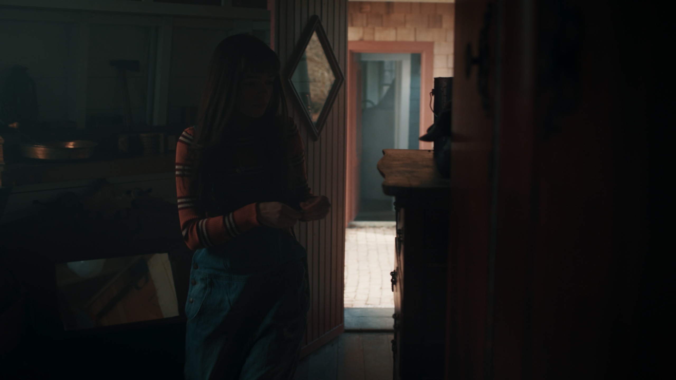 Woman in dark cabin doorway with daylight spilling through