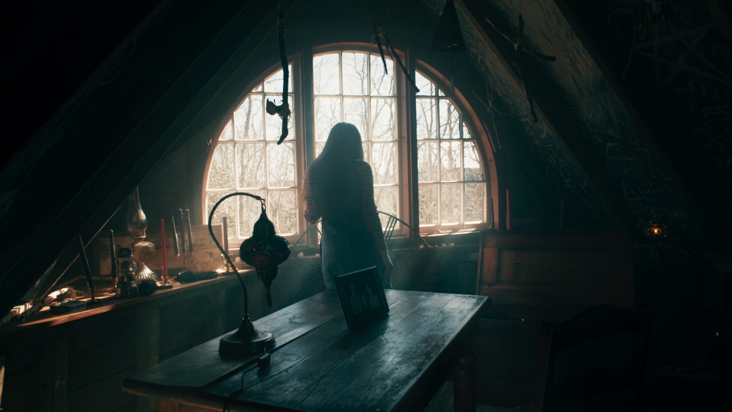 Silhouette gazing through arched attic window