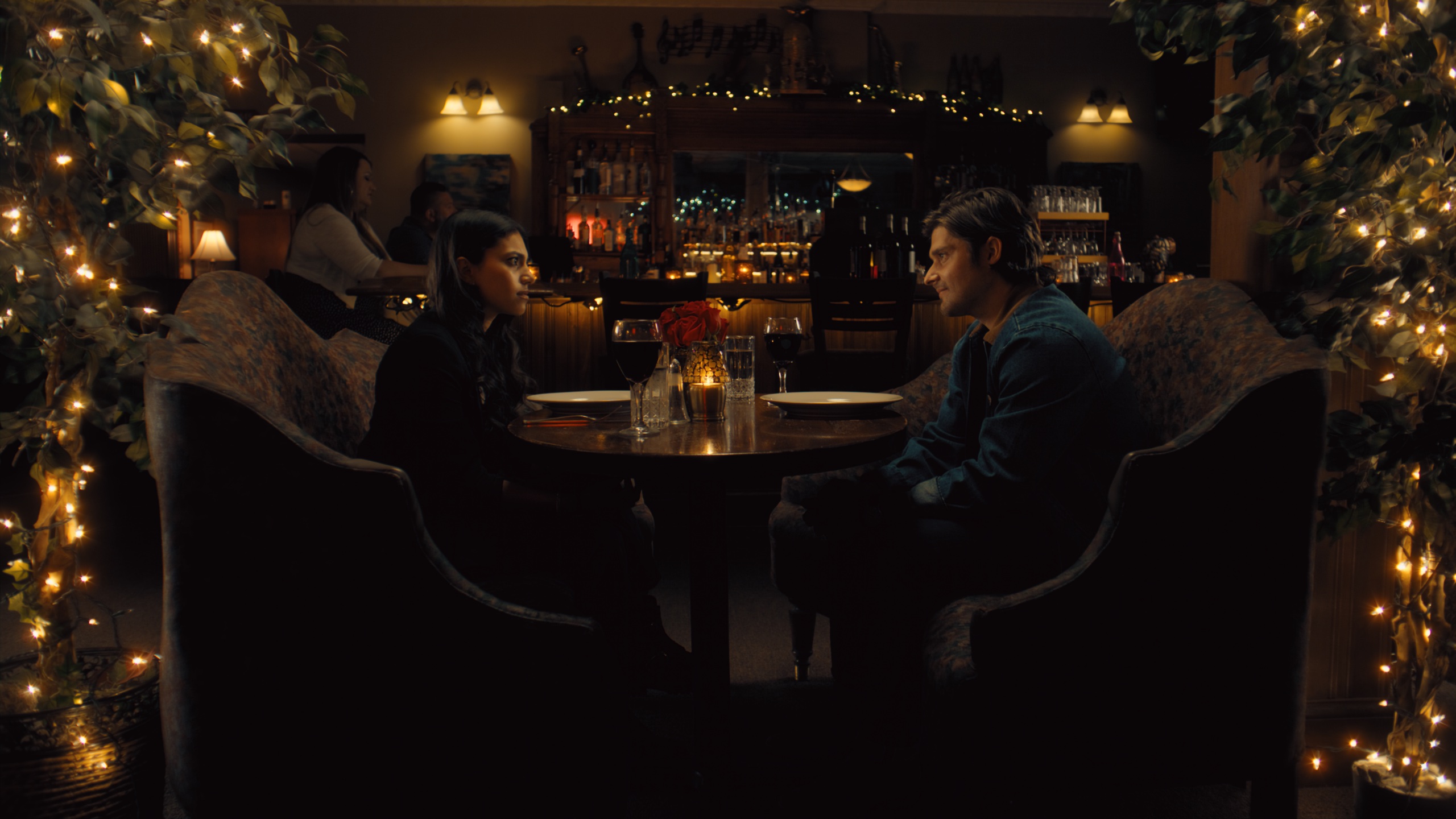 Couple at table surrounded by string lights