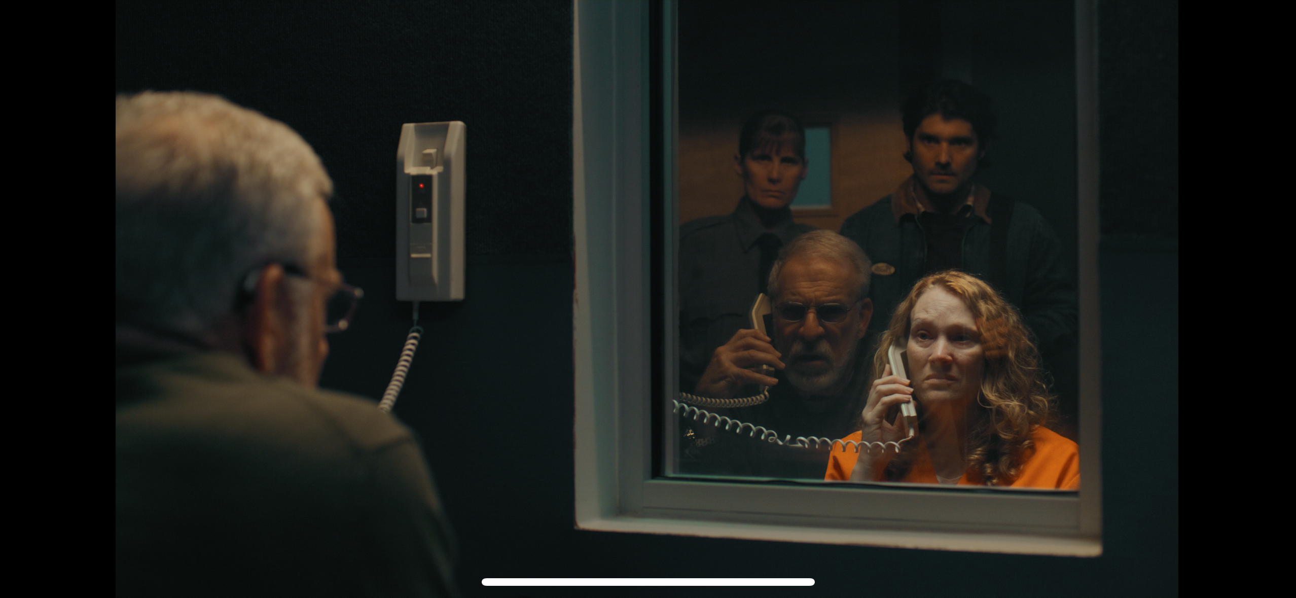 Prison visitation scene through glass