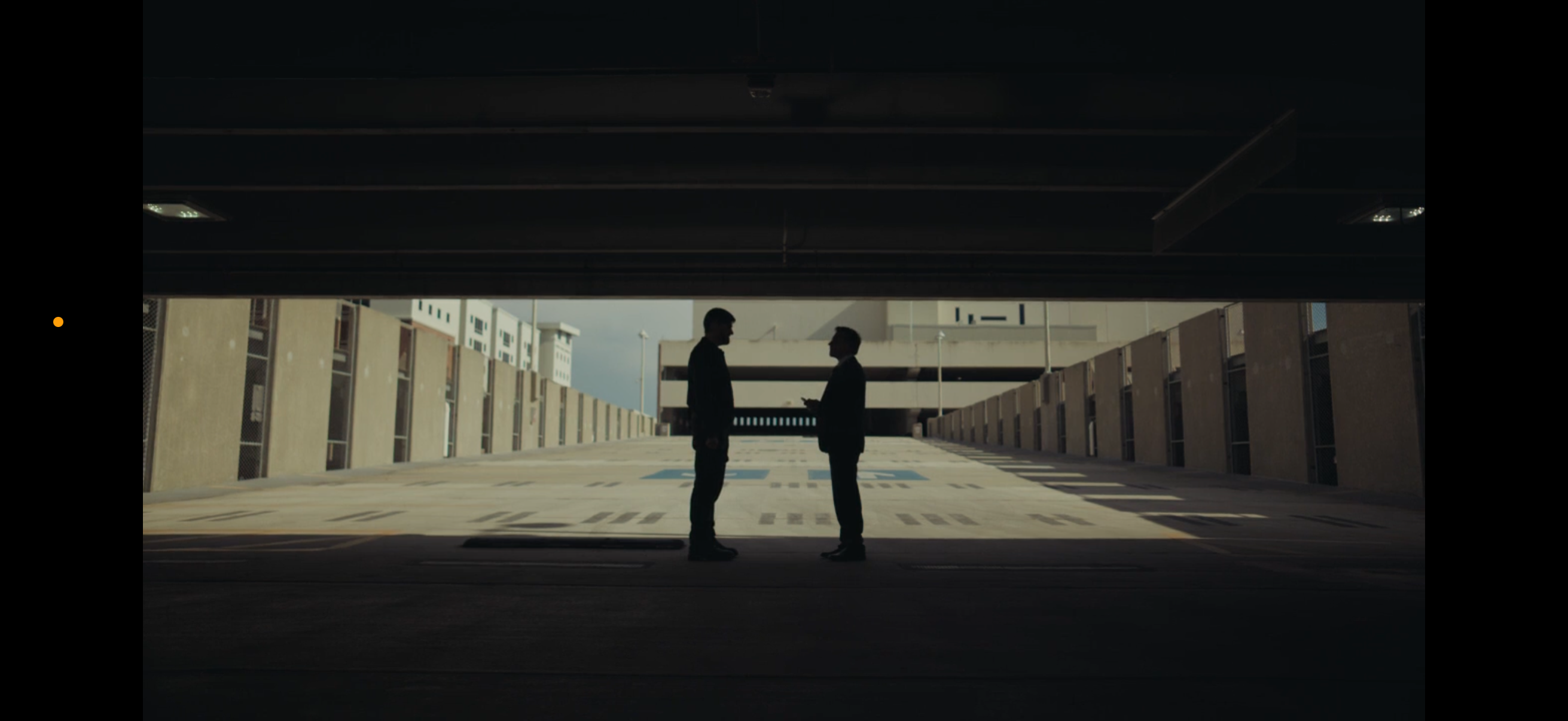 Silhouette of two figures in a parking garage